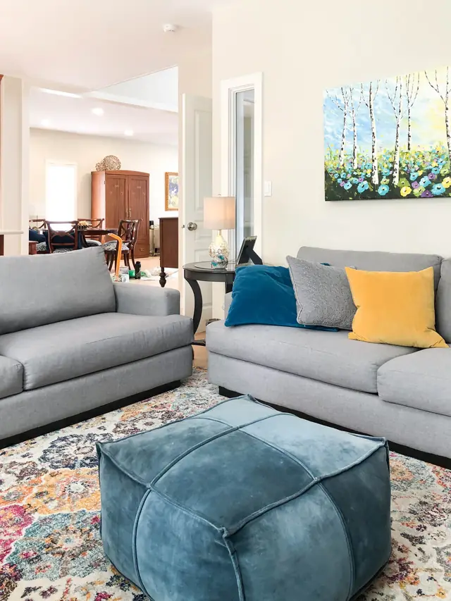 Bright repainted living room with a grey sofa and framed art