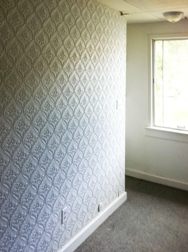 Hallway finished in a damask-pattern wall covering